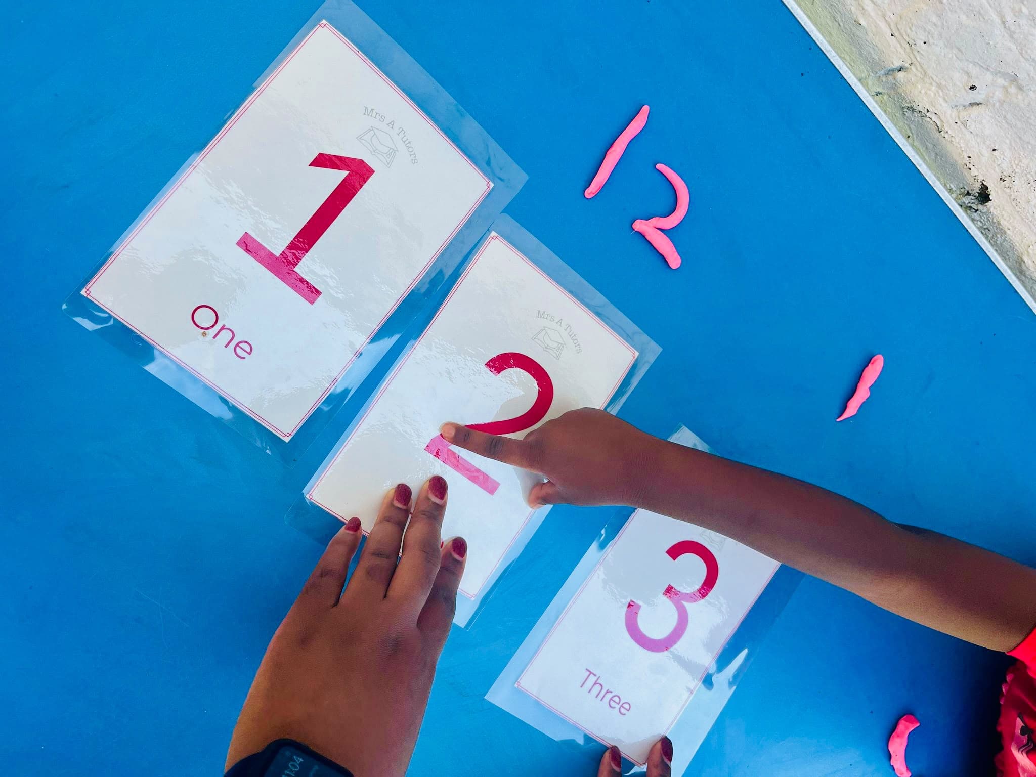 A child placing foam number cards 1, 2 and 3 during a hands-on tuition session